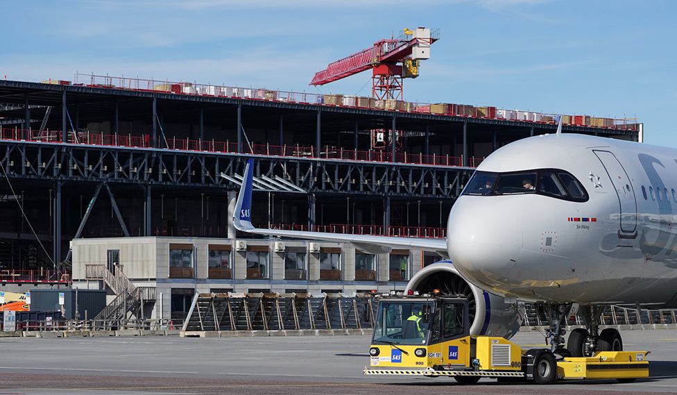 Et fly taxier i Københavns Lufthavn og i baggrund ser man byggeriet i gang af udvidelsen af lufthavnen. Fotos: Københavns Lufthavne A/S